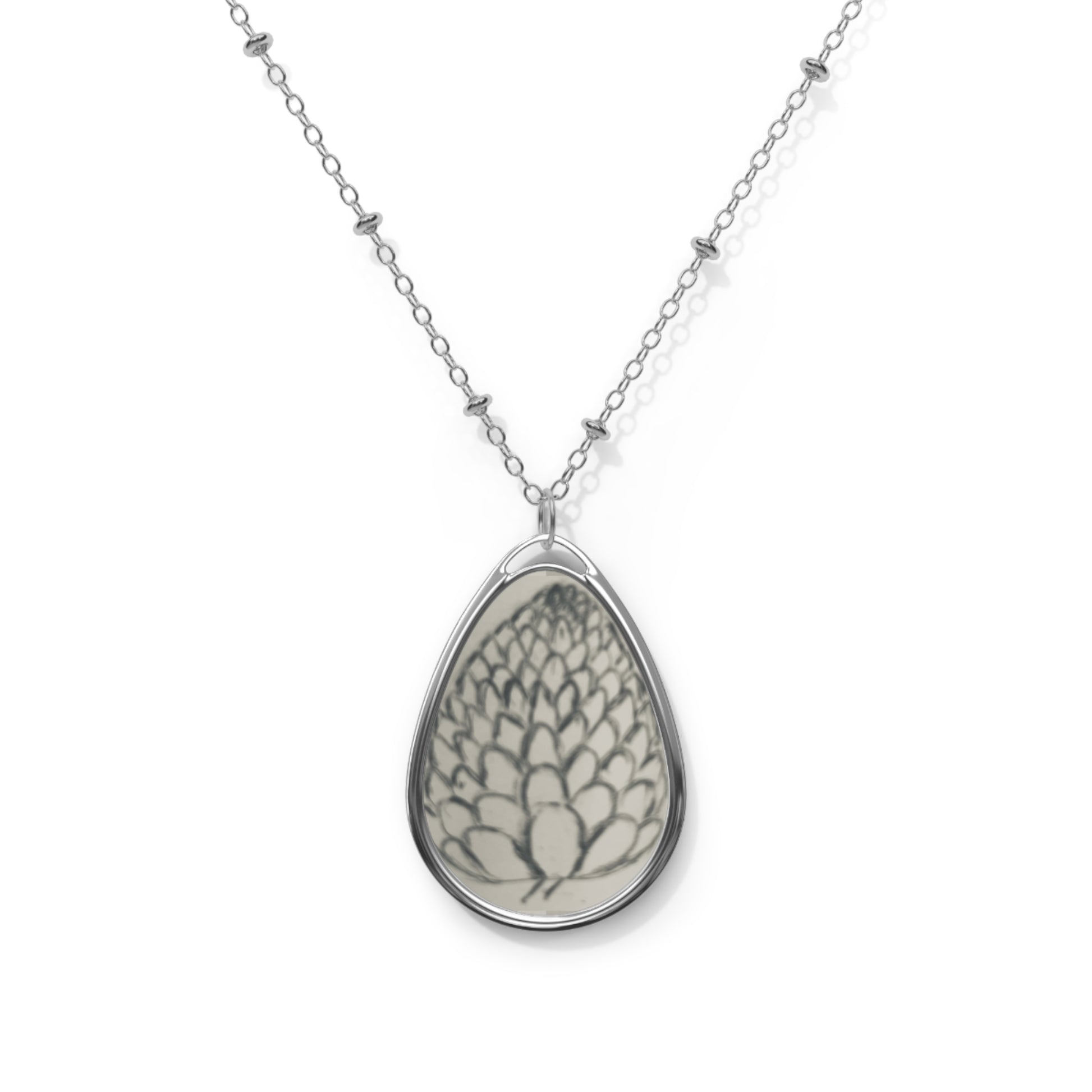 Teardrop-shaped pendant with floral design on a silver chain against a white background